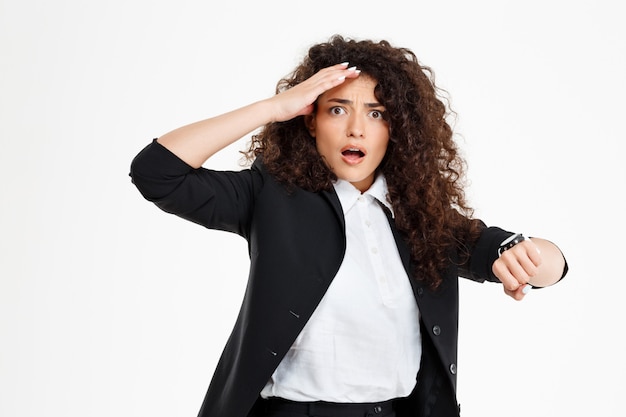 Photo gratuite jeune fille bouclée tendre regardant la montre et inquiet que la fin