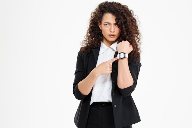 Photo gratuite jeune fille bouclée tendre regardant la montre et inquiet que la fin