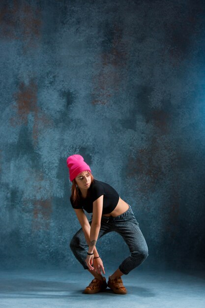 Jeune fille break dance sur fond de mur.