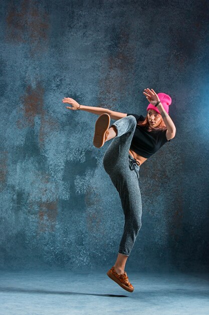 Jeune fille break dance sur fond de mur.