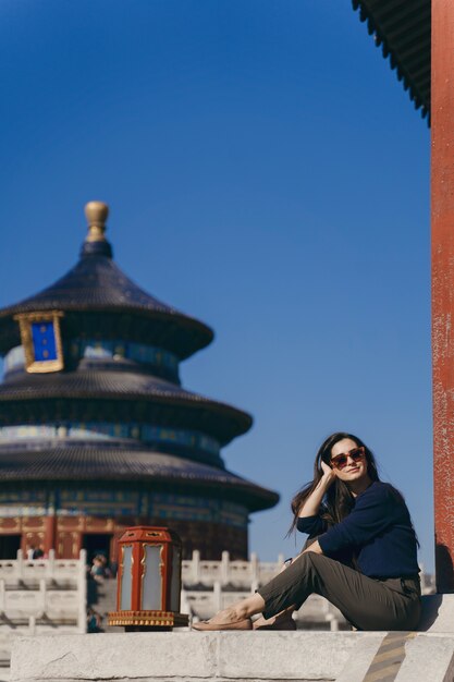 Jeune fille brune assise sur les marches du temple d'Héven en Chine