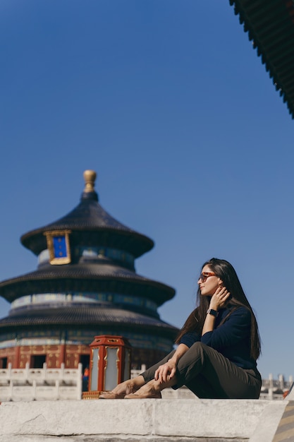 Jeune fille brune assise sur les marches du temple d'Héven en Chine