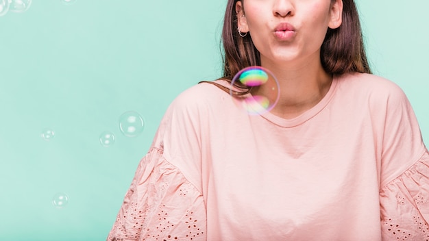 Jeune fille brune jouant avec des bulles de savon