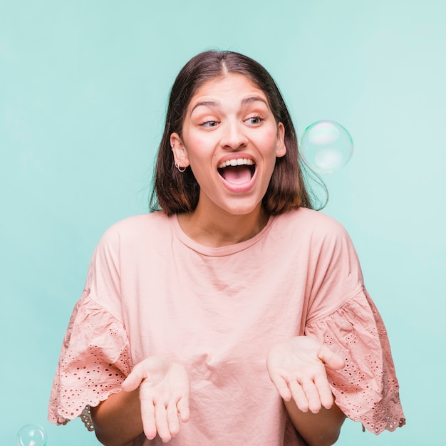 Jeune fille brune jouant avec des bulles de savon