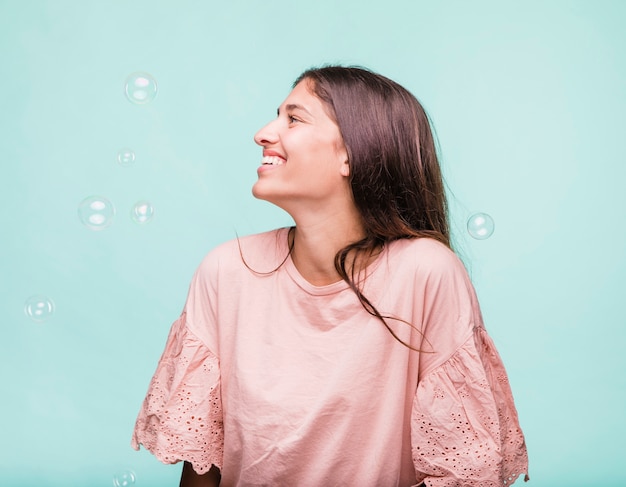 Jeune fille brune jouant avec des bulles de savon