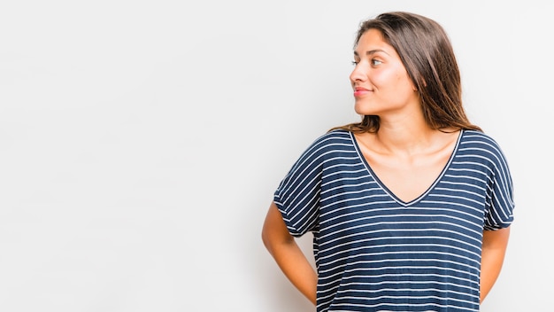 Jeune fille brune posant avec une chemise rayée