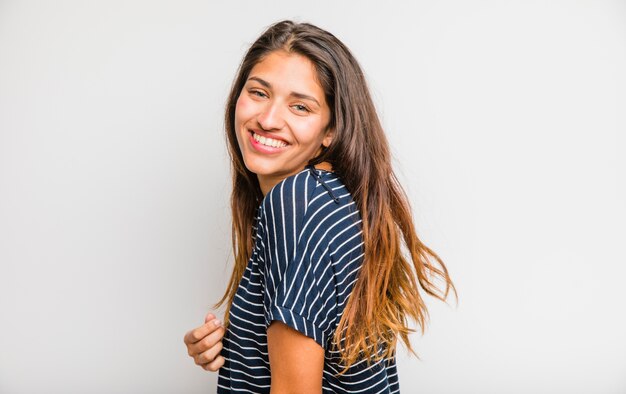 Jeune fille brune posant avec une chemise rayée