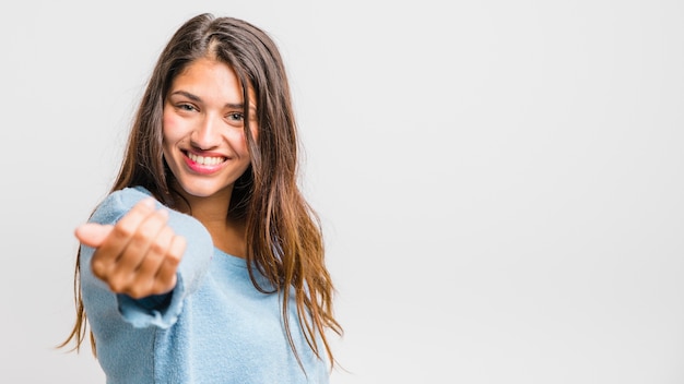 Jeune fille brune posant avec un pull bleu