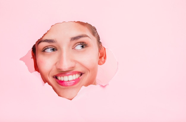 Jeune Fille Brune Posant à Travers Un Trou De Papier