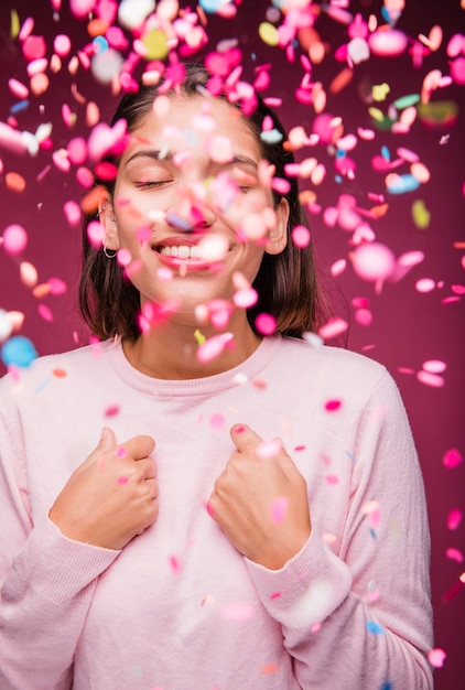 Photo gratuite jeune fille brune souriante avec des confettis