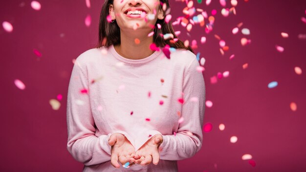 Jeune fille brune souriante avec des confettis