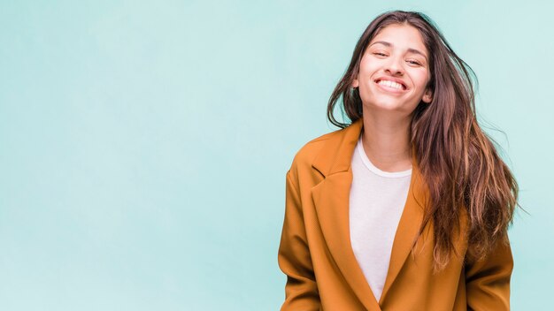 Photo gratuite jeune fille brune souriante posant avec manteau