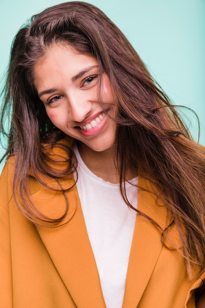 Photo gratuite jeune fille brune souriante posant avec manteau