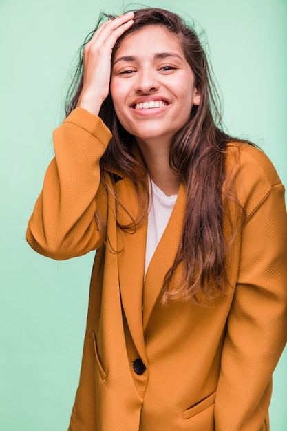 Jeune fille brune souriante posant avec manteau