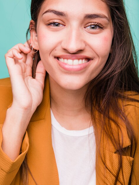 Jeune fille brune souriante posant avec manteau