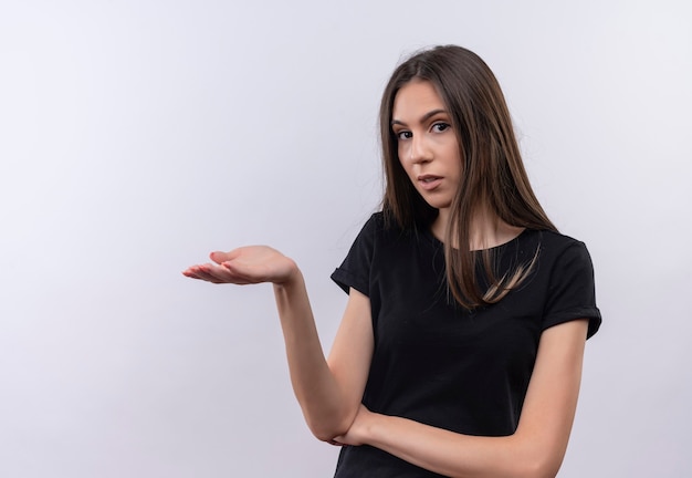 Jeune fille caucasienne portant un t-shirt noir, levant la main sur un mur blanc isolé