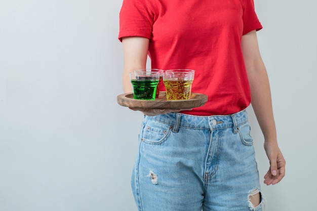 Jeune fille en chemise rouge tenant un plateau de boissons