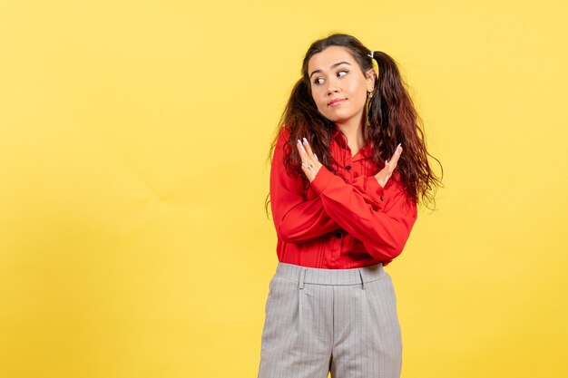 jeune fille en chemisier rouge posant sur jaune