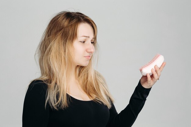 Jeune fille confuse aux cheveux blonds en désordre