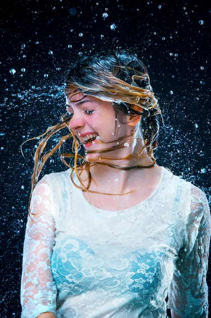 jeune fille debout sous l'eau courante