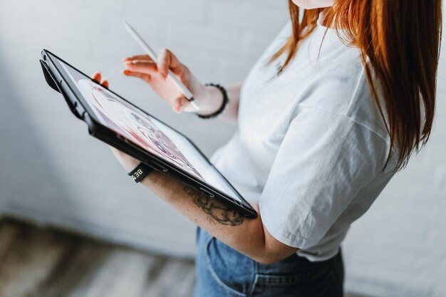 Jeune fille dessinant sur tablette à l'intérieur