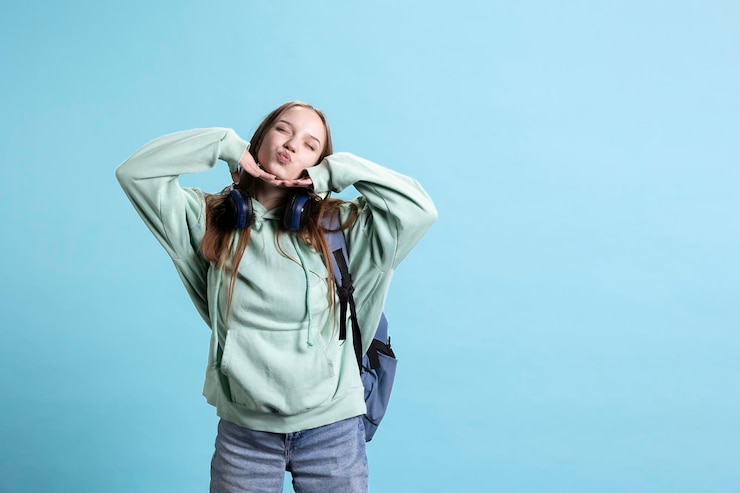 Photo gratuit une jeune fille enjouée qui souffle des baisers à la caméra.