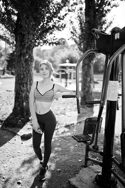 Jeune fille a l'entraînement et fait de l'exercice à l'extérieur sur des simulateurs de rue Sport concept d'entraînement de rue de remise en forme