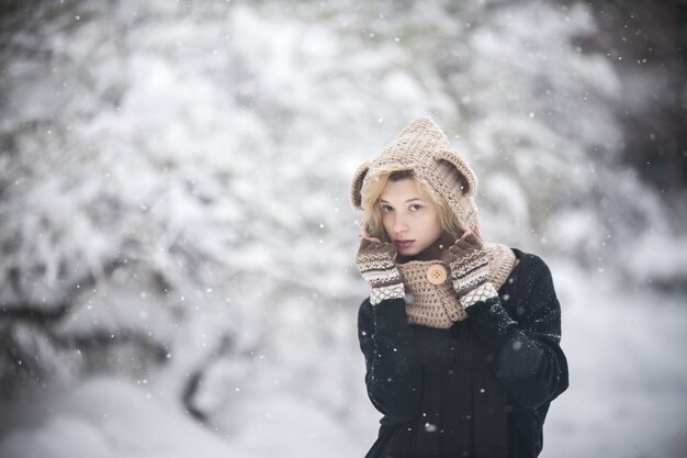 Jeune fille enveloppée dans la neige avec arrière-plan flou