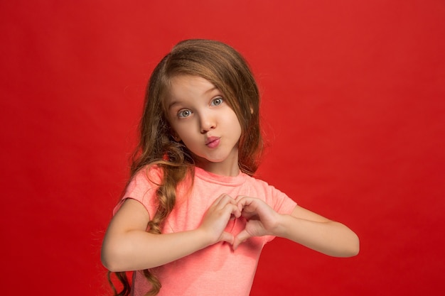 Jeune fille envoyant un baiser et faisant signe de coeur avec les mains