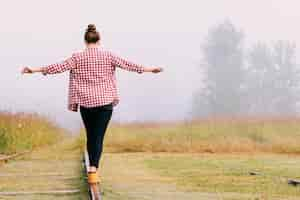 Photo gratuite jeune fille en équilibre sur le chemin de fer