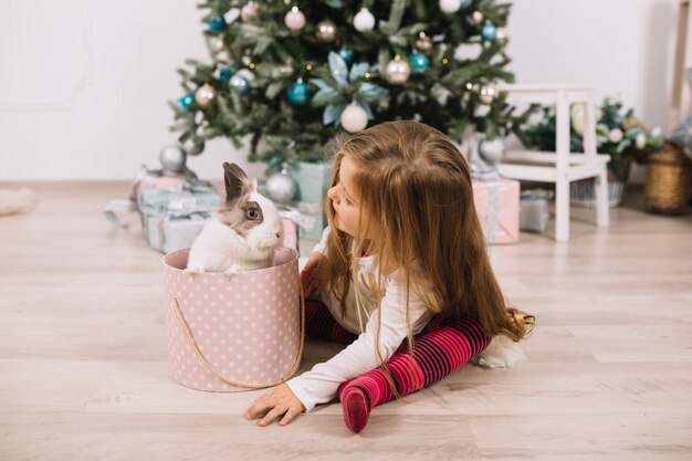 Jeune fille en face de l&#39;arbre de Noël à la maison