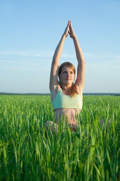 Jeune fille faisant du yoga contre la nature