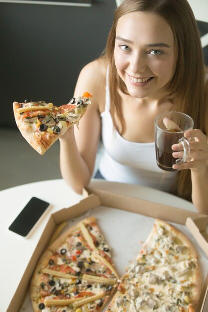 Jeune fille heureuse avec une tranche de pizza