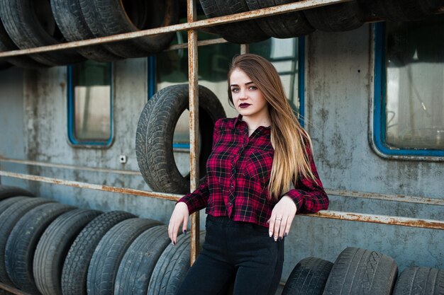 Jeune fille hipster en chemise à carreaux à la zone de montage des pneus