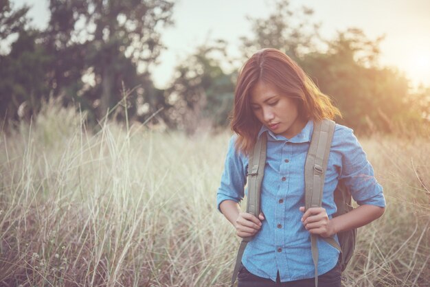 Jeune fille hipster avec sac à dos marche à travers dans le domaine de l&#39;été.