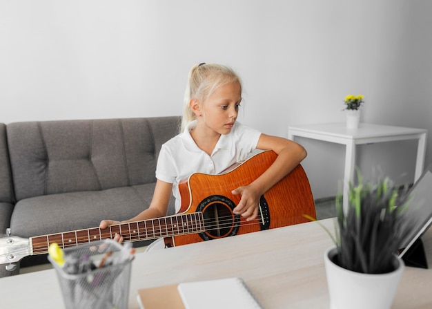 Jeune Fille Jouant De La Guitare à La Maison