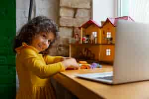 Photo gratuite jeune fille jouant à l'intérieur avec des jouets écologiques