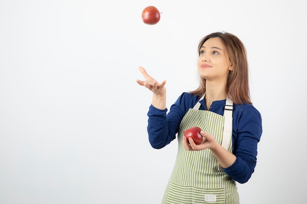 jeune fille jouant avec des pommes rouges sur blanc.