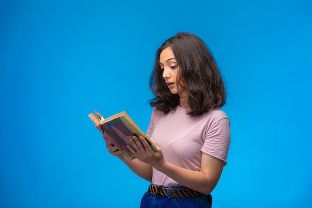 Photo gratuite jeune fille lisant un vieux livre.