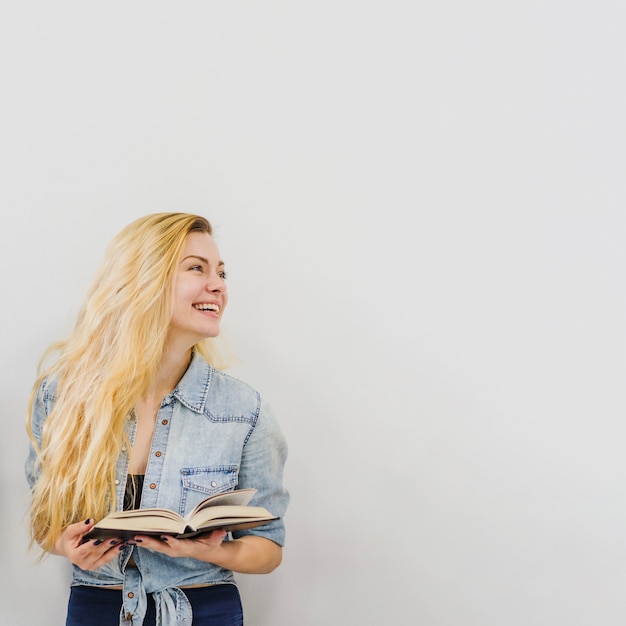 Jeune fille avec un livre riant