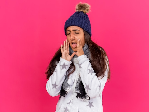 Jeune fille malade aux yeux fermés portant un chapeau d'hiver avec écharpe appelant quelqu'un isolé sur rose