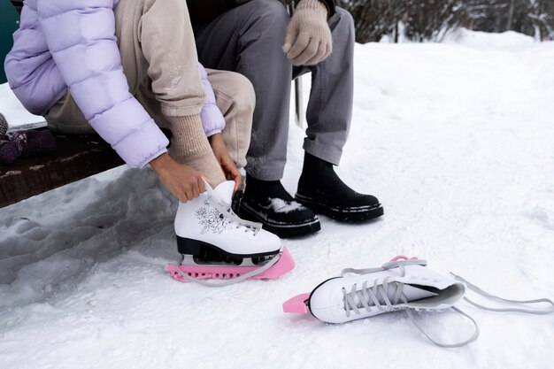 Jeune fille mettant ses patins à glace avec l'aide de son père