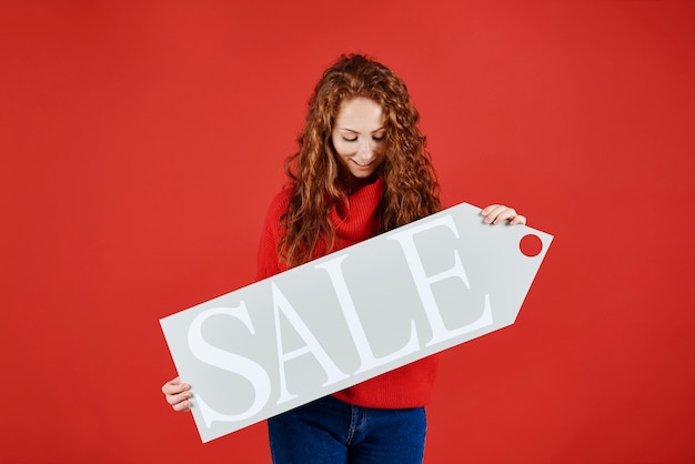 Photo gratuite jeune fille montrant la bannière de la vente d'hiver