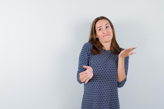 Jeune fille montrant je ne sais pas le geste de la main sur fond blanc