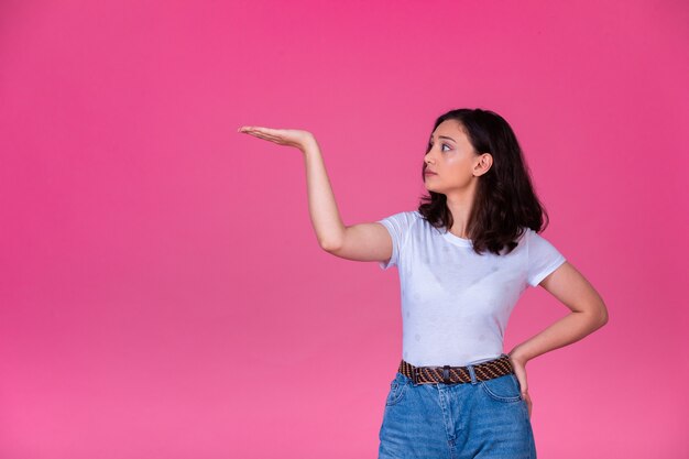 La jeune fille ouvre la main et introduit quelque chose.