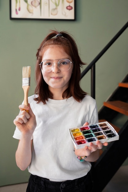 Photo gratuite jeune fille avec de la peinture pour un projet de recyclage