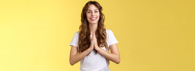 Une jeune fille polie, joyeuse, confiante et sociable dit namaste, accueille les invités asiatiques et sourit avec joie.