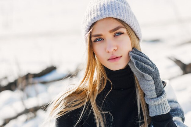 Jeune fille portant une couverture sur un champ enneigé