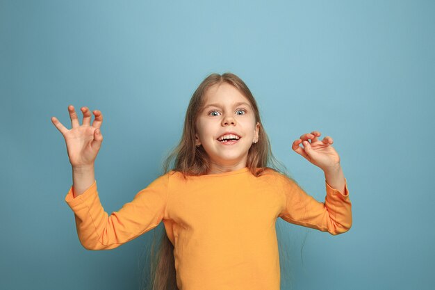 Jeune fille posant contre le mur bleu