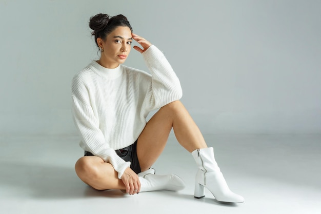 Une jeune fille pose sa main sur sa tête et regarde la caméra avec confiance Photo de haute qualité